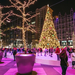 People skate around an illuminated Christmas tree in downtown Pittsburgh.